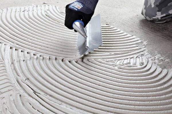 a worker applying tile adhesive